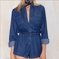 A Sleek Coating Brightens Up The Medium Blue Wash Of A Lightweight Denim Romper Featuring A Long-Sleeve, Button-Front Top Studded With Copper Snaps And Relaxed Shorts. 35 1/2" Length; 2 1/2" Inseam; 28.5” Leg Opening. Front Snap-Button Closure. Spread Collar. Two-Button Barrel Cuffs. 100% Cotton. Machine Wash Cold, Tumble Dry Low. Fits True To Size. Large = 10-12 High Waist Denim Tops For Fall, Fall High Waist Denim Tops, Blue Denim Long Sleeve Jumpsuits And Rompers, Blue Long Sleeve Denim Jumpsuits And Rompers, Casual Fitted Solid Denim Jumpsuit, Fitted Denim Jumpsuit Casual, Casual Medium Wash Long Sleeve Denim Jumpsuit, Solid Fitted Casual Denim Jumpsuit, Casual Long Sleeve Medium Wash Denim Jumpsuit