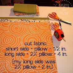 an orange and white table with some scissors and other items on it, including fabric