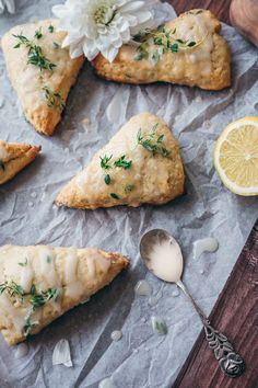 lemon filled pastries on wax paper next to a spoon and flower with silverware