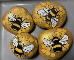 four painted rocks with bees on them