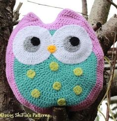 a crocheted owl sitting on top of a tree branch