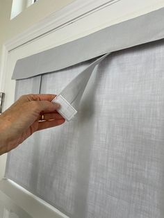 a person is holding a piece of cloth over the window