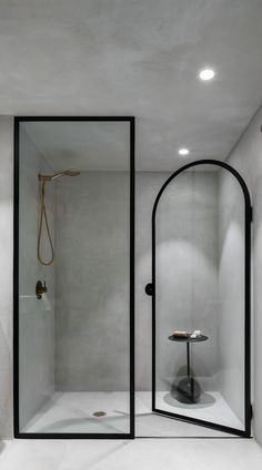 a bathroom with a shower, sink and mirror in it's corner area that is lit up by recessed lights