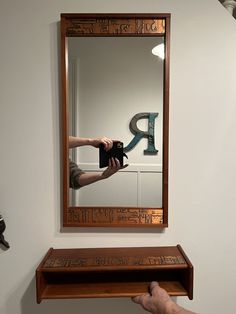 a person holding up a camera in front of a mirror