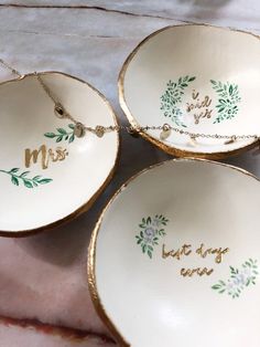 three white dishes with gold rims that say,'mr and mrs'on them