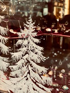 a white christmas tree in a store window