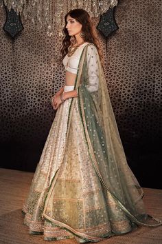 a woman in a white and green lehenga