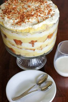 a cake with white frosting and nuts on top next to a glass of milk