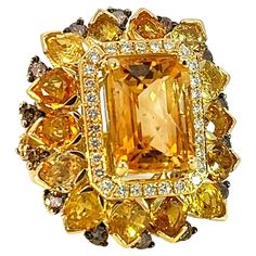 This sunshine stunning ring from S.Georgios designer was handmade in our workshop in Greece from solid 18 Karat Yellow Gold. The ring features 9.7 Carats of Faceted Citrine center surrounded by 10.1 Carats of pear-cut sapphires, a row of Brilliant Cut White Diamonds with a total weight of 0.45 Carats, and 1.38 Carats of Brown Diamonds with Black Rhodium prongs on the outer edge. The band is beautifully shaped to comfort and decorated with Yellow Sapphire hearts and brown diamonds on the sides. This is a beautiful one-of-a-kind ring. The ring is unique and outstanding in quality and is made in our workshop in Athens Greece. Frond Height: 31 mm Front Width: 27 mm 18 K gold Weight: 29.2 grams Size: 7.5 (can be custom-sized, please contact us) For a full selection of S.Georgios jewelry please Brown Diamonds, Sapphire Diamond Ring, Brown Diamond, Domed Ring, Black Rhodium, Beast Mode, Yellow Sapphire, Beautiful One, Sapphire Diamond