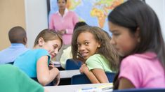 several children sitting at desks in a classroom