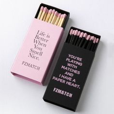 two matches are in a pink box and one is black with white writing on it