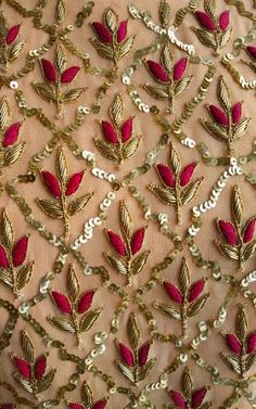 a red and gold embroidered fabric with leaves on the side, along with sequins