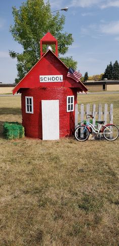 a bike is parked in front of a red building with a school sign on it