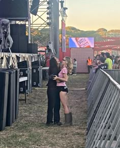 two people standing next to each other at a music festival