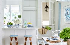 a kitchen with two stools in front of an island