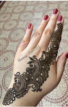 a woman's hand with henna tattoos on it