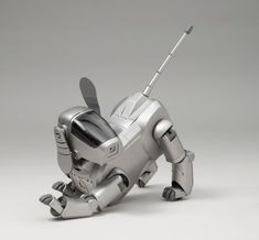 a silver robot dog is laying down on the ground