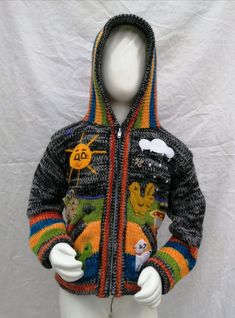 a white mannequin wearing a multicolored jacket with cartoon characters on it