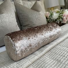 a close up of a bed with pillows and flowers