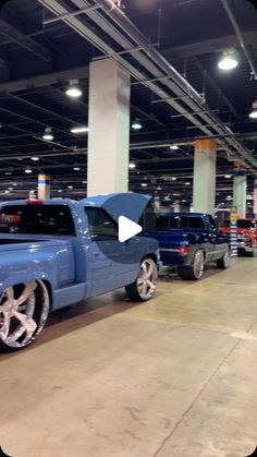 a blue truck parked in a garage next to other cars