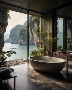 a large bath tub sitting on top of a bathroom floor next to a window overlooking the ocean