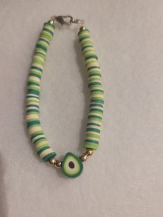 My daughter makes clay beaded jewelry. Her current creation is an avocado bracelet.  The second bracelet is a made to order bracelet with an initial charm. She will also take orders for specific colors, names, or charms. Green Heart Beads Bracelet Jewelry, Green Heart Beads Bracelet, Handmade Green Heishi Beads Bracelets, Adjustable Green Charm Bracelet With Colorful Beads, Green Adjustable Charm Bracelet With Colorful Beads, Green Heishi Bead Jewelry Bracelet, Trendy Handmade Green Charm Bracelet, Trendy Green Heishi Beads Bracelets, Trendy Green Handmade Charm Bracelet