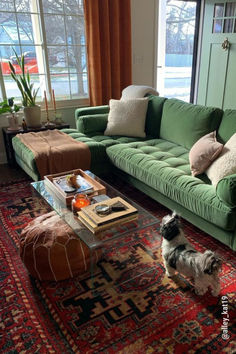 a living room with green couches and rugs on the floor in front of large windows