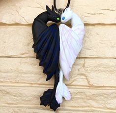 two black and white birds hanging from a wall