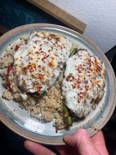 someone is holding a plate full of food with rice and meat on it, including peppers