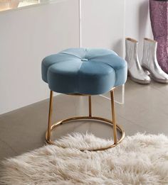 a blue stool sitting on top of a white rug in front of a wall and floor