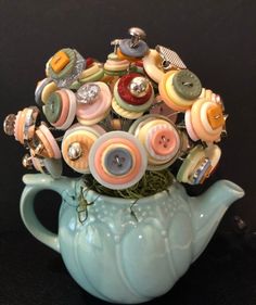 a blue vase filled with lots of buttons