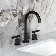 two black faucets sitting on top of a marble counter