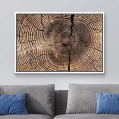 a living room with a couch and a painting on the wall above it that has a tree stump pattern