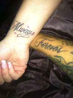 two people holding hands with the words always forever tattooed on their arm and wrist, both in cursive font