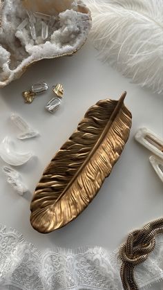 an assortment of jewelry and feathers on a white surface