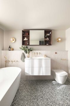 a bathroom with a sink, toilet and bathtub next to a mirror on the wall