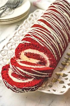 a red velvet roll with white frosting on a plate