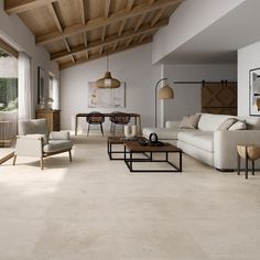 a living room filled with white furniture and wooden ceiling beams on top of a hard wood floor