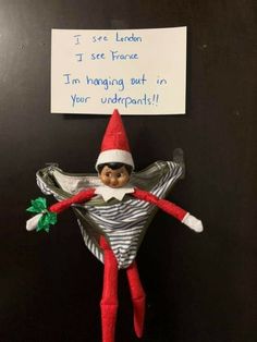 an elf is hanging on the wall with a note