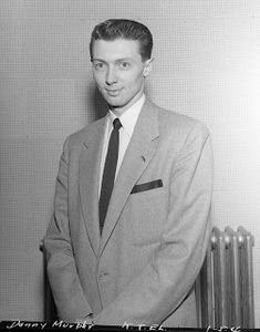 a man in a suit standing next to a radiator