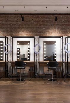 a hair salon with chairs and lights in front of mirrors on the wall behind them