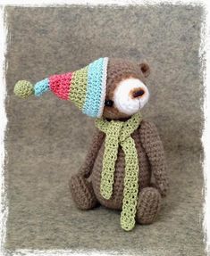 a crocheted teddy bear with a hat and scarf