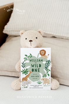 a teddy bear sitting on top of a bed next to a sign that says william the wild one