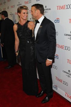 a man and woman standing next to each other on a red carpet at an event