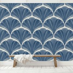 a bench in front of a blue wallpaper with scallop designs on it