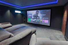 a home theater with two couches and a projector screen