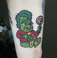 a person with a tattoo on their arm holding a candy lolly popper ball