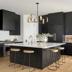 a kitchen with black cabinets and wooden floors