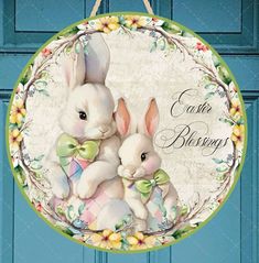 two white rabbits sitting in front of a blue door with the words easter blessing on it