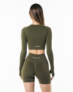 HIGHLIGHTS. Contour lines to enhance the body shape. Crew neckline. Low impact. Long line length LS crop. Raglan cut long sleeve. Form-fitting and cropped cut. Alphalete wordmark logo printed in the back FIT SUGGESTION. This item runs true to Alphalete’s standard seamless fit.. If you are between sizes, we recommend sizing up.. Model is 5’8”/172cm, wearing a size XS with a 31”/78cm bust. MATERIALS AND WASHING DIRECTIONS. 51% Polyamide, 38% Polyester, 11% Elastane. We recommend washing inside-out Fitted Green Athleisure Crop Top, Green Fitted Athleisure Crop Top, Fitted Long Sleeve Elastane Activewear, Long Sleeve Compression Tops With Seamless Construction, Seamless Fitted Long Sleeve Activewear, Fitted Cropped Activewear With Thumbholes, Seamless Long Sleeve Elastane Activewear, Seamless Fitted Cropped Activewear, Fitted Long Sleeve Seamless Crop Top